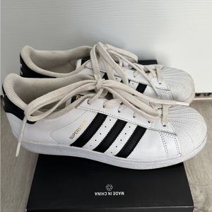 Women’s Adidas Superstar size 7 sneakers in white with black stripes.